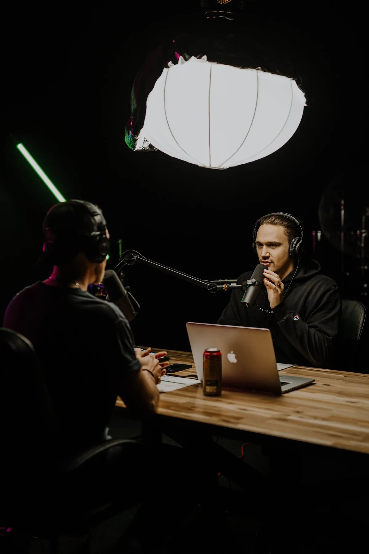 Podcast host recording an episode at a mic with a laptop